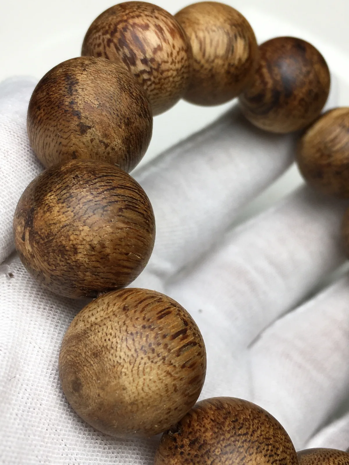 Matching bracelets: a round agarwood strand for one wrist