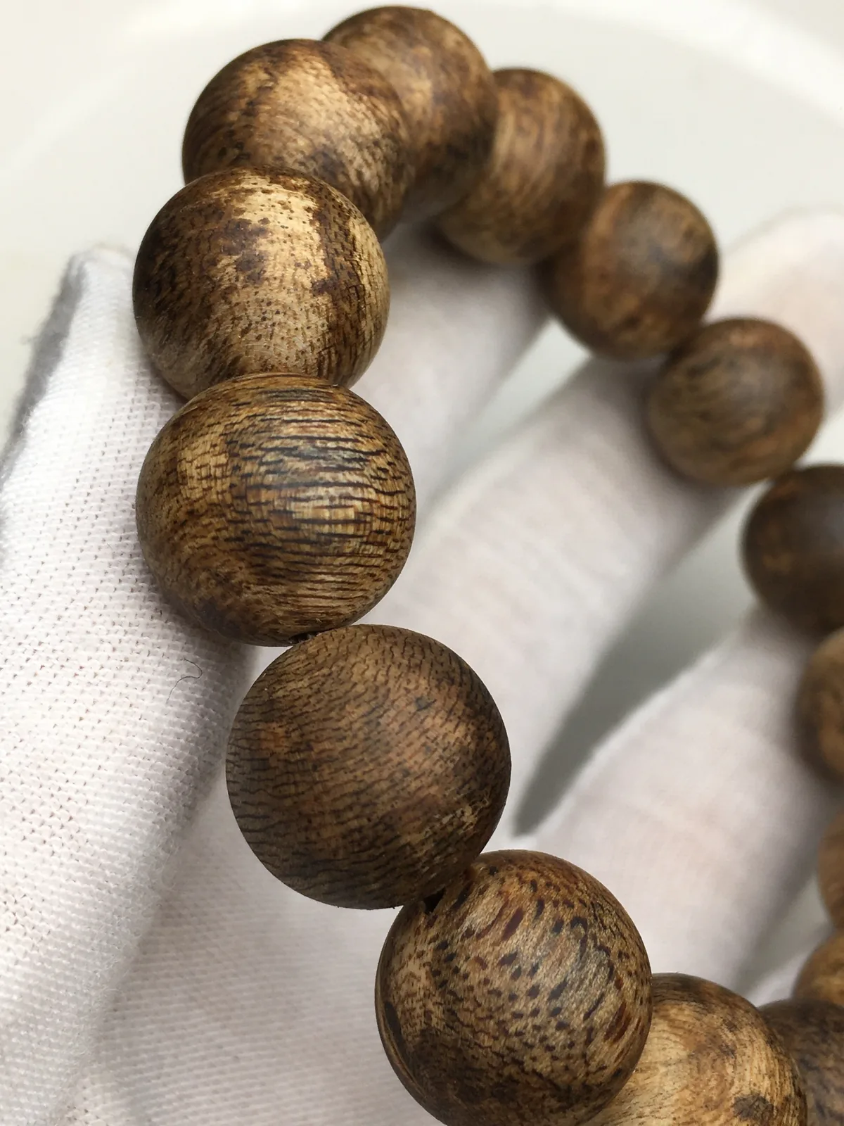 A second round agarwood strand of the same style